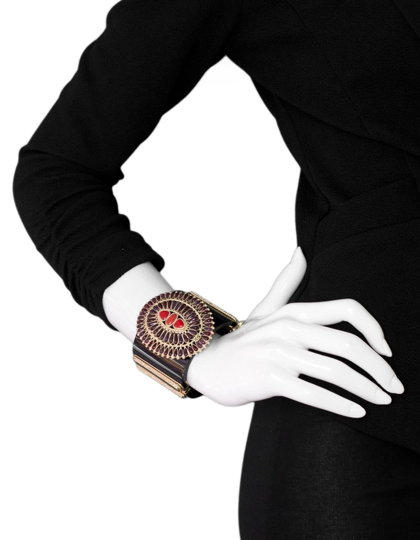 Chanel Black and Red Paris/Dallas 2014 Cuff

Made In: France
Materials: Resin, metal, poured glass
Closure/Opening: Notch closure
Stamp: Chanel A14 CC C MAde in France
Overall Condition: Very good pre-owned condition with the exception of some small