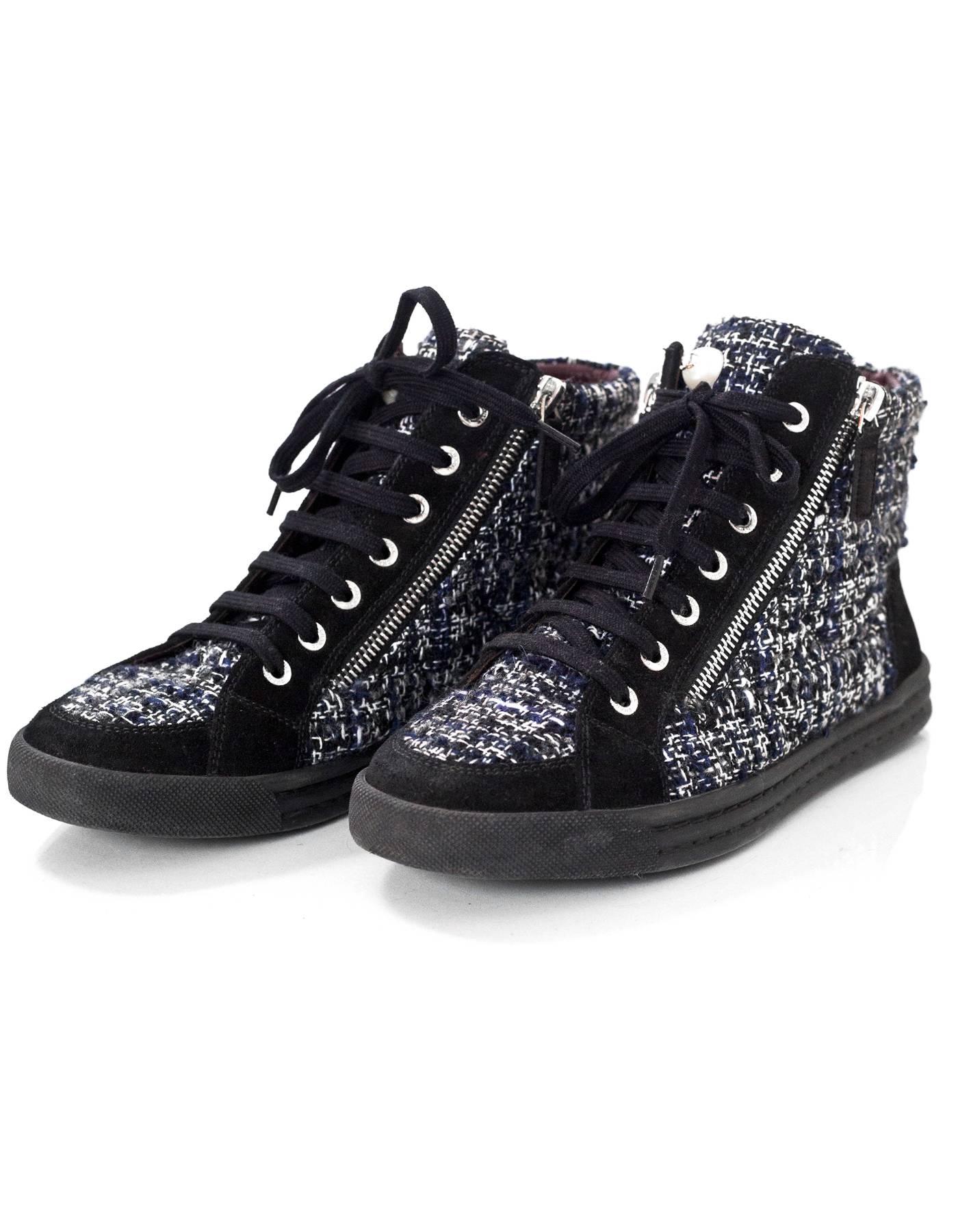 Chanel Black, White & Grey Tweed High Top Sneakers Sz 37

Made In: Italy
Color: Black, white, grey
Materials: Tweed, leather, suede, rubber
Closure/Opening: Lace tie closure with side zipper details
Sole Stamp: Chanel made in italy
Overall