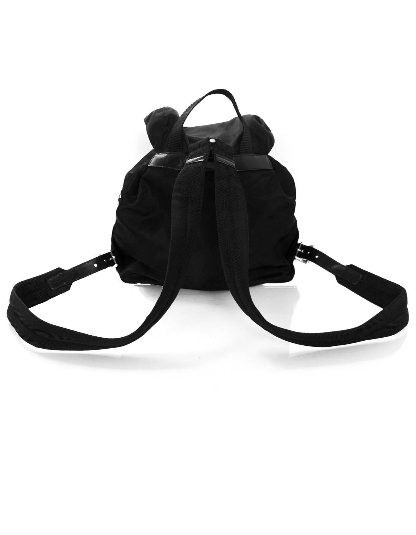 Prada Black Tessuto Backpack

Made In: Italy
Color: Black
Hardware: Silver
Materials: Tessuto nylon
Lining: Black textile
Closure/Opening: Drawstring with flap top and buckle closure
Exterior Pockets: Two front pockets
Interior Pockets: One zip