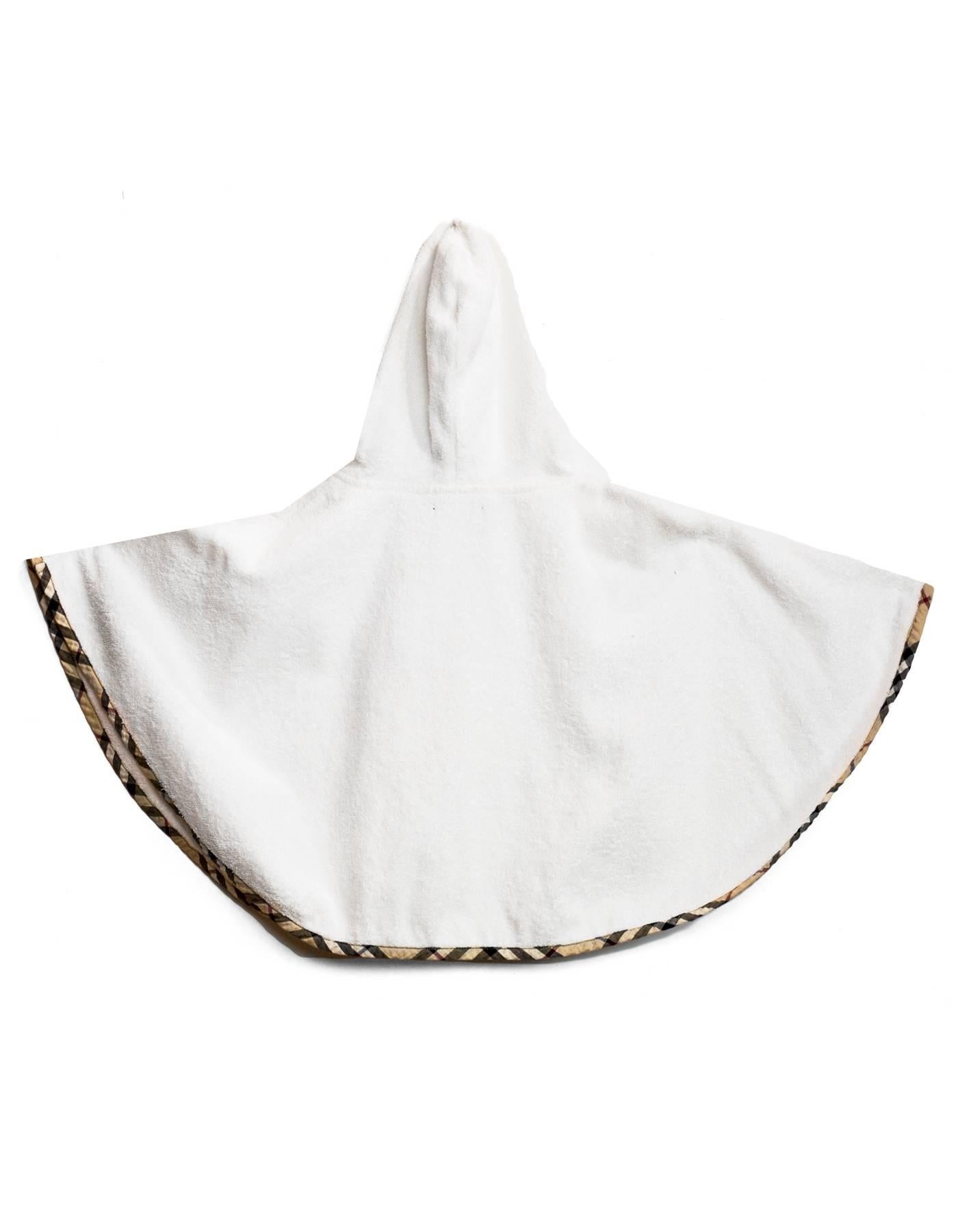 Burberry London White Terrycloth Hooded Children's Capelet
Features nova plaid piping and trim throughout and bow at neckline

Made In: Romania
Color: White, nude, black and red
Composition: 100% cotton
Lining: White, 100% cotton
Closure/Opening: