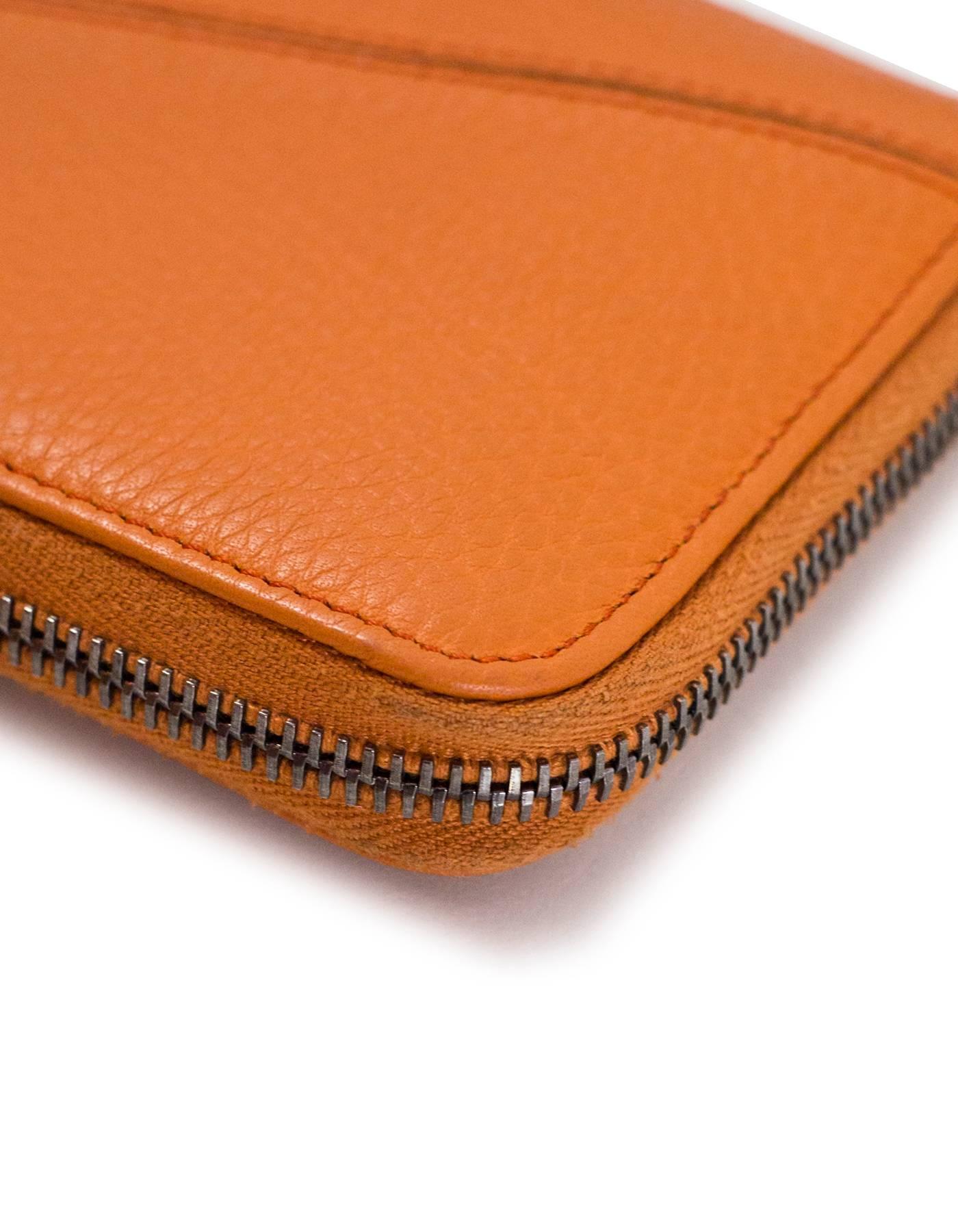 Tod's Orange Leather Zip Around Wallet

Made In: Italy
Color: Orange
Hardware: Silvertone
Materials: Leather, metal
Lining: Orange leather and black textile
Closure/Opening: Zip around closure
Exterior Pockets: None
Interior Pockets: Zip pouch,