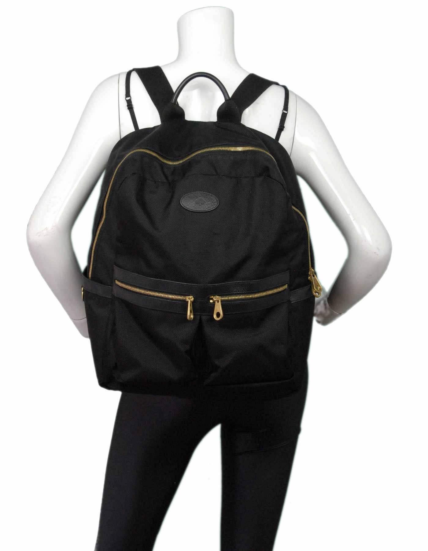 Mulberry Black Textured Nylon Henry Backpack

Color: Black
Hardware: Goldtone
Materials: Nylon, leather
Lining: Black textile
Closure/Opening: Double zip top
Exterior Pockets: Two front zip pockets, side flat pockets
Interior Pockets: Zip wall