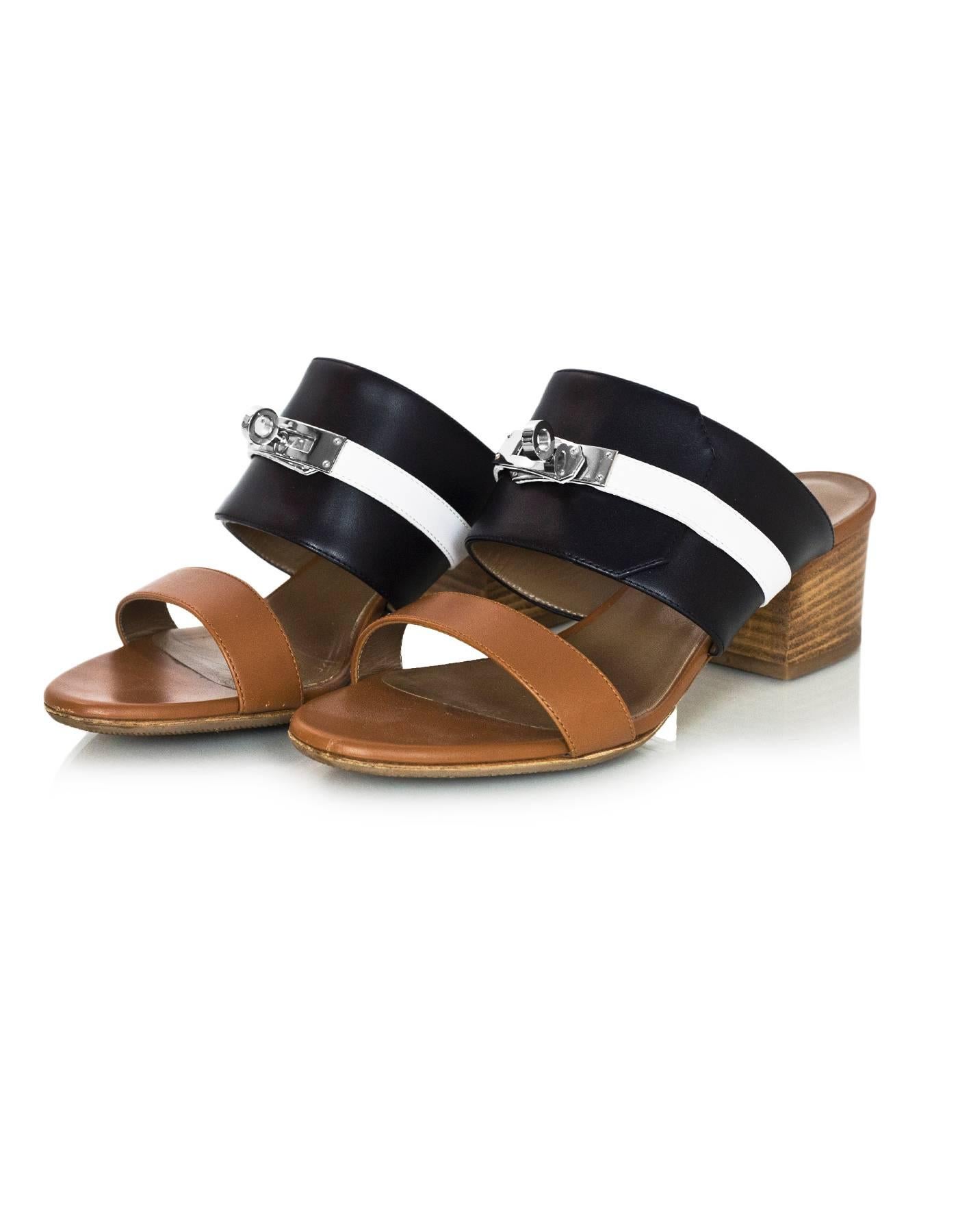 Hermes Tri-Color Palissandre Leather Ovation Kelly Lock Sandals Sz 36

Made In: Italy
Color: Tan, black, white
Materials: Calfskin leather
Closure/Opening: Slide on
Sole Stamp: Hermes 36 Semelle Cuir Made in Italy
Retail Price: $1,100 + tax
Overall