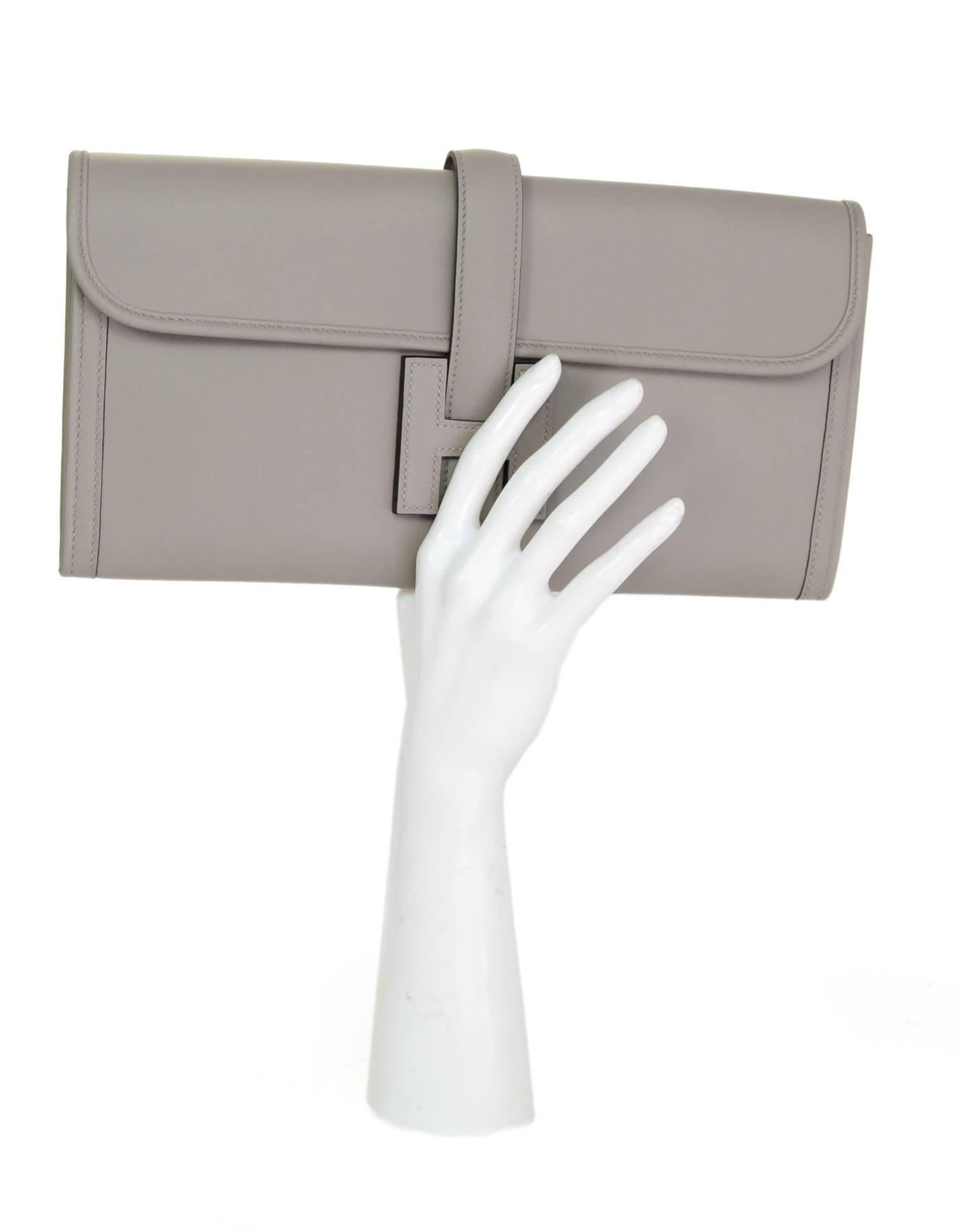 Hermes Grey Swift Leather Jige Elan 29 Clutch

Made In: France
Year of Production: 2017
Color: Grey
Hardware: None
Materials: Swift leather
Lining: Leather
Closure/opening: Flap top with strap that goes through H
Exterior Pockets: None
Interior