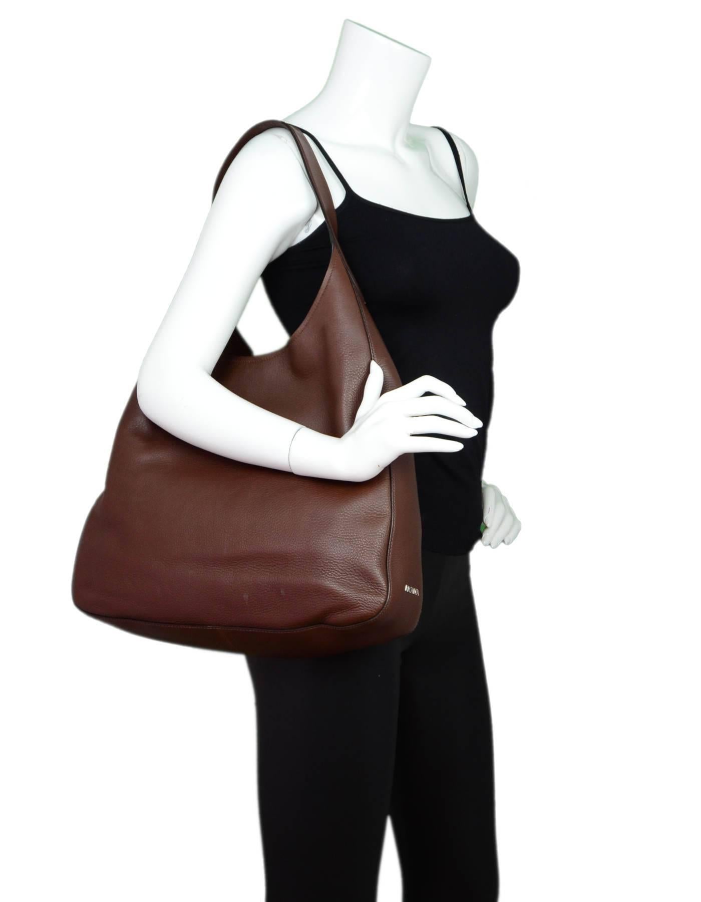 Prada Radica Brown Vitella Corsica Leather Hobo Bag

Made In: Italy
Color: Brown
Materials: Leather
Lining: Brown textile
Closure/Opening: Open top with center magnetic closure 
Exterior Pockets: One patch pocket
Interior Pockets: Wall pocket, zip