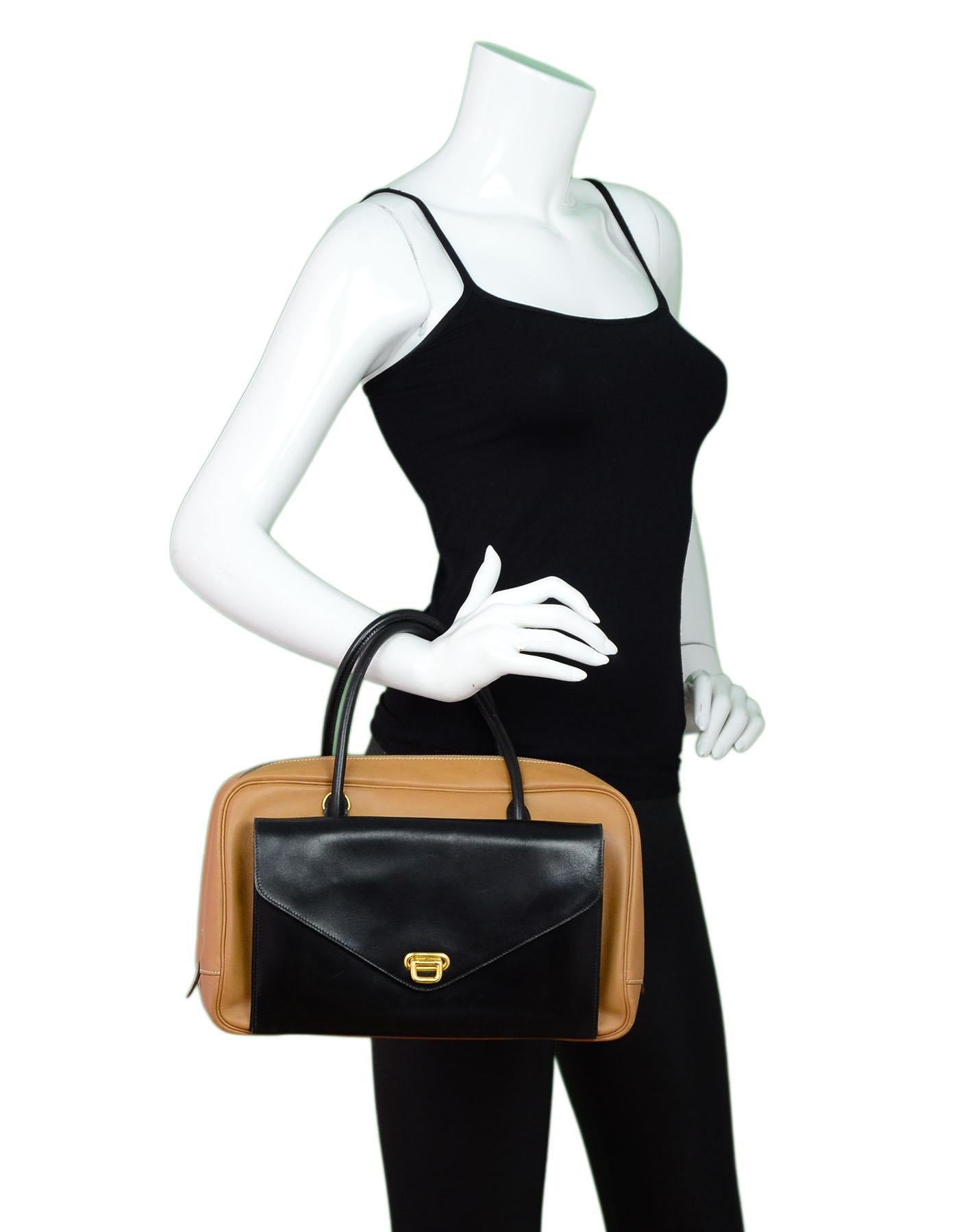 Hermes Vintage Tan & Black Leather Handbag

Made In: France
Year of Production: 1994
Color: Black, tan
Hardware: Goldtone
Materials: Leather, metal
Lining: Black leather
Closure/Opening: Top zip closure
Exterior Pockets: Front flap pocket
Interior