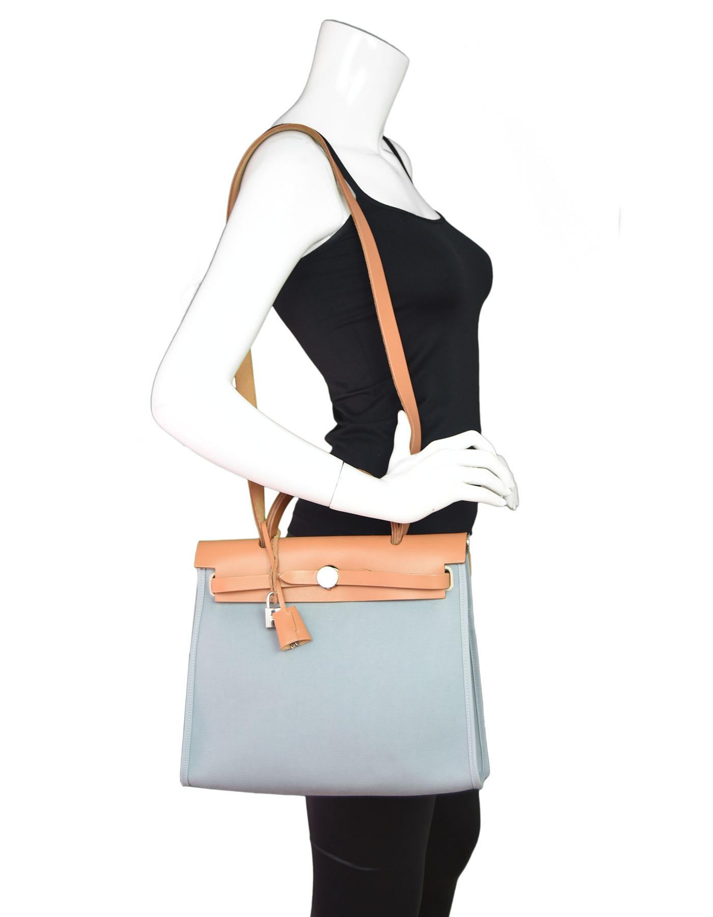 Hermes Blue & Tan Toile Officer Vache Hunter Herbag Zip 31 PM

Made In: France
Color: Light blue, tan
Year Of Production: 2015
Hardware: Palladium
Materials: Leather, canvas
Lining: None
Closure/opening: Flap top with arms on each end that go