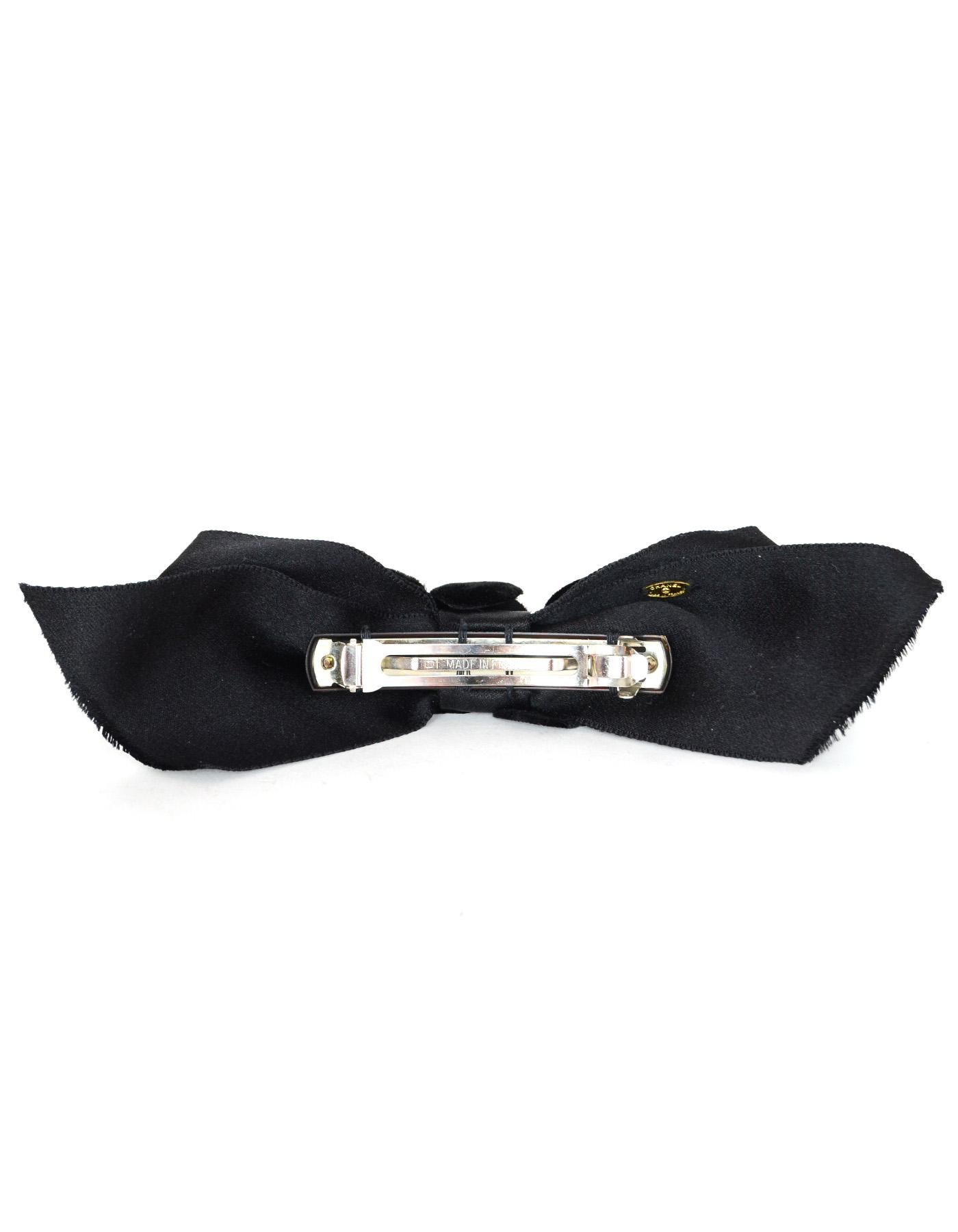 Chanel Black Satin Bow Hair Accessory With Velvet Camelias And Box, Vintage. Featuring Raw Edge On Sides Of Bow And French Clip Closure on Back.

Made In: France
Year of Production: 1990
Color: Black
Hardware: Silvertone hair clip in back
Materials: