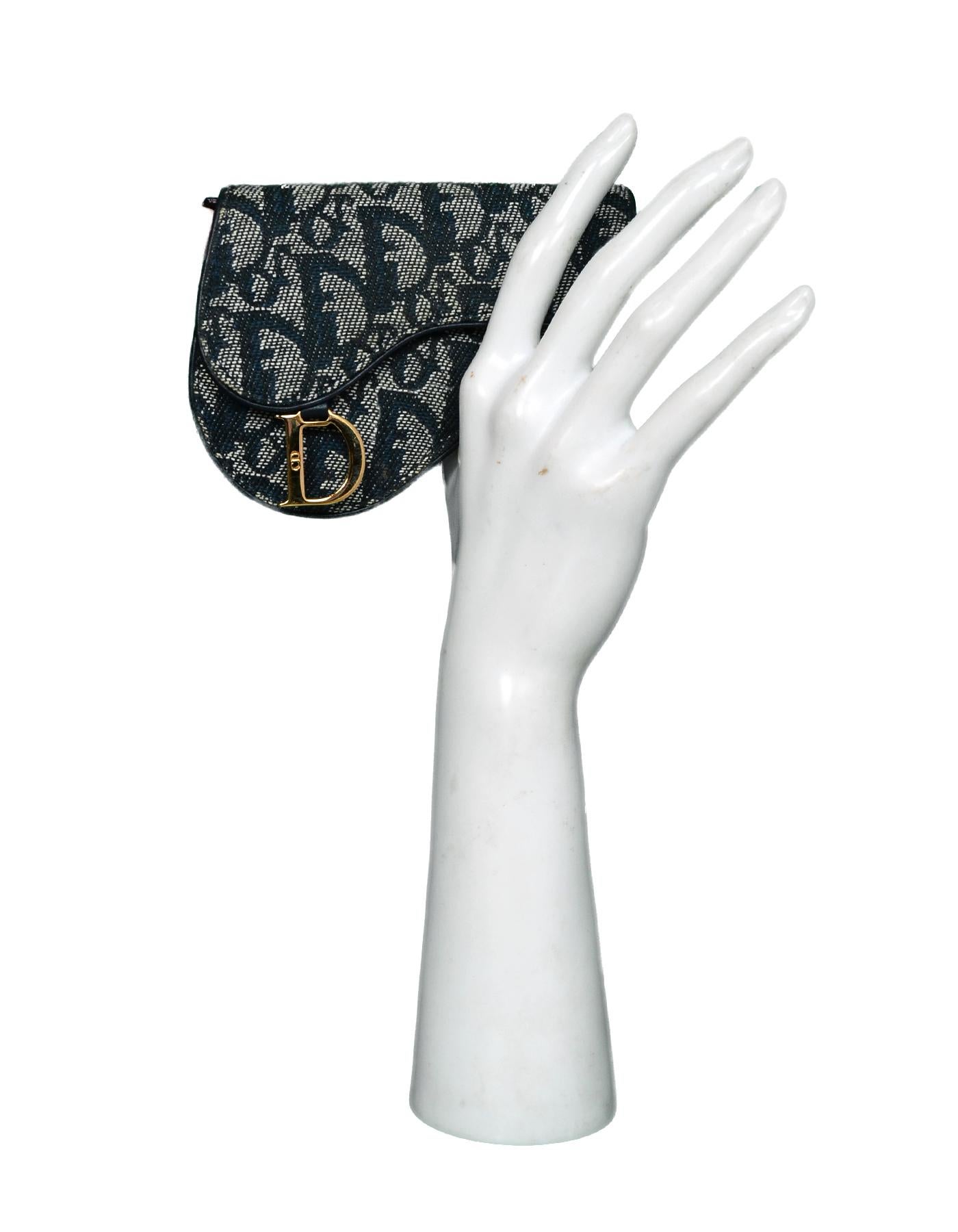 Christian Dior Blue Monogram Saddle Coin Purse

Made In: Italy
Year of Production: 2001
Color: Navy blue
Hardware: Goldtone
Materials: Canvas, leather, and metal
Lining: Blue leather and canvas
Closure/Opening: Flap with snap closure 
Exterior