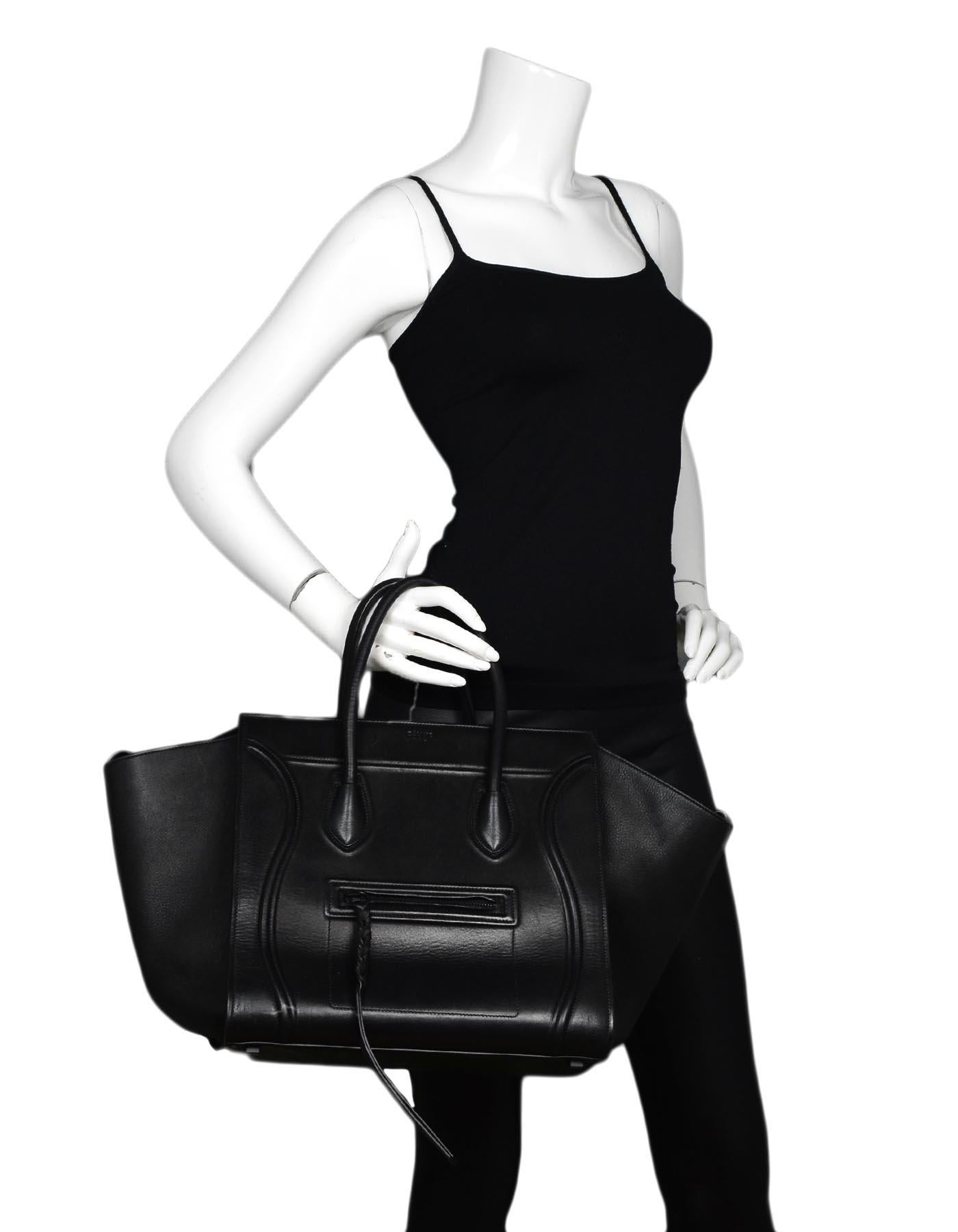 Celine Black Leather Phantom Trapeze Winged Luggage Bag 

Made In: Italy
Color: Black
Hardware: Black
Materials: Leather
Lining: Black suede
Closure/Opening: Open top with strap closure
Exterior Pockets: Front facing zipper pocket
Interior Pockets: