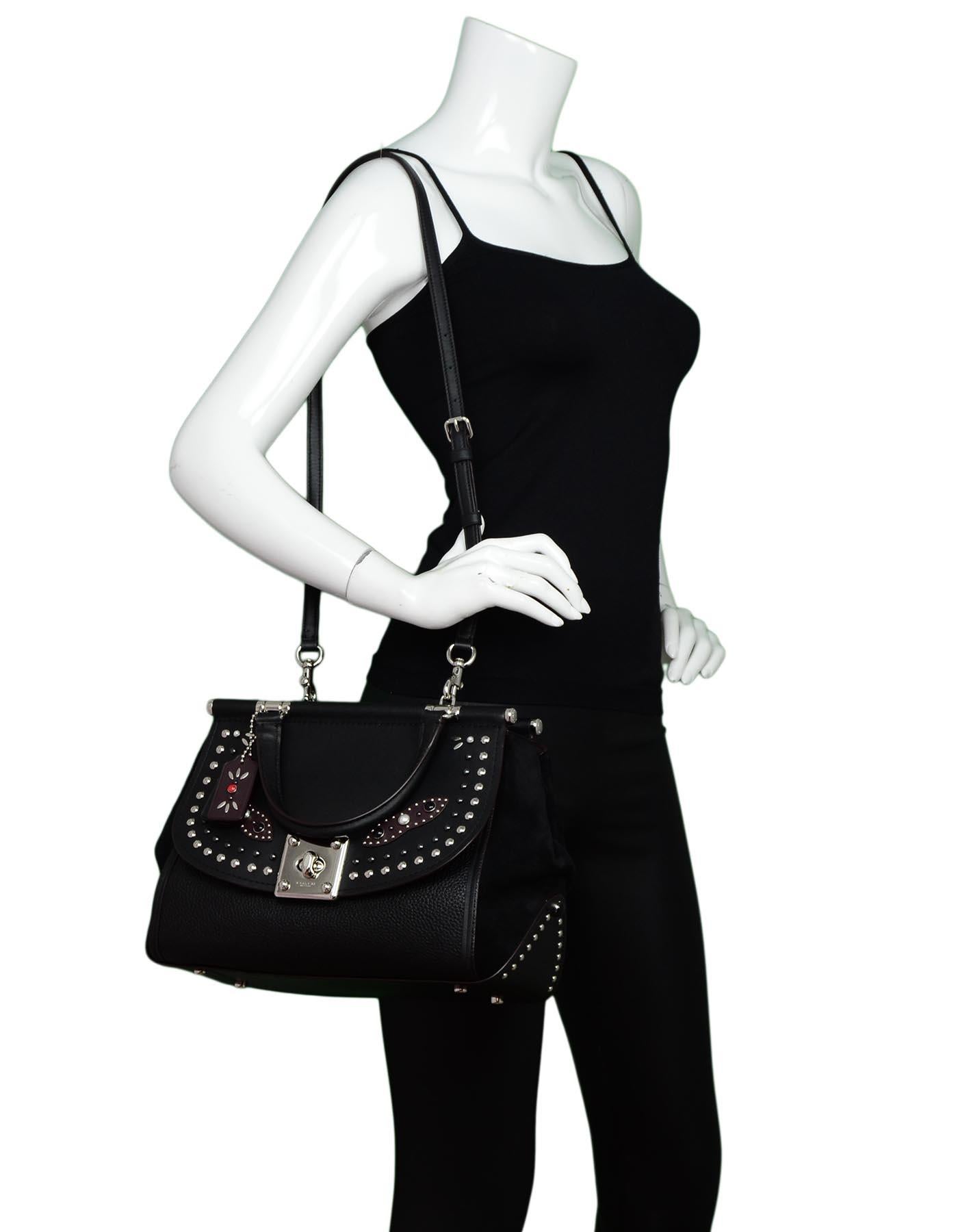 Coach Black Leather/Suede Studded Embellished Drifter Carryall Bag W/ Strap

Made In: Vietnam
Color: Black
Hardware: Silvertone 
Materials: Leather/suede
Lining: Burgundy leather in main compartment, burgundy jacquard logo lining in front flap