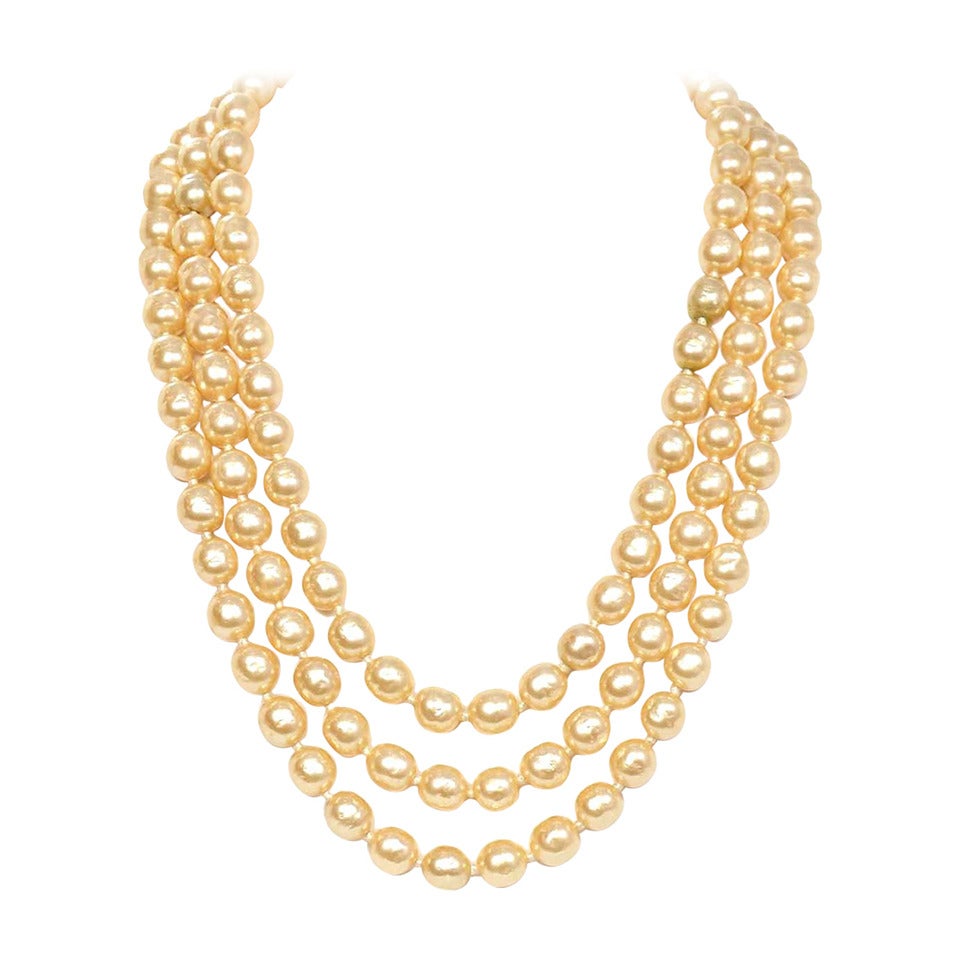 Chanel Vintage '50s-'60s Three Strand Pearl Necklace
Features intricate antiqued brass clasp

Year of Production: 1950's-1960's
Stamp: CHANEL
Closure: Lever with push and click opening/closure
Color: Ivory and antiqued bras
Materials: Faux pearls