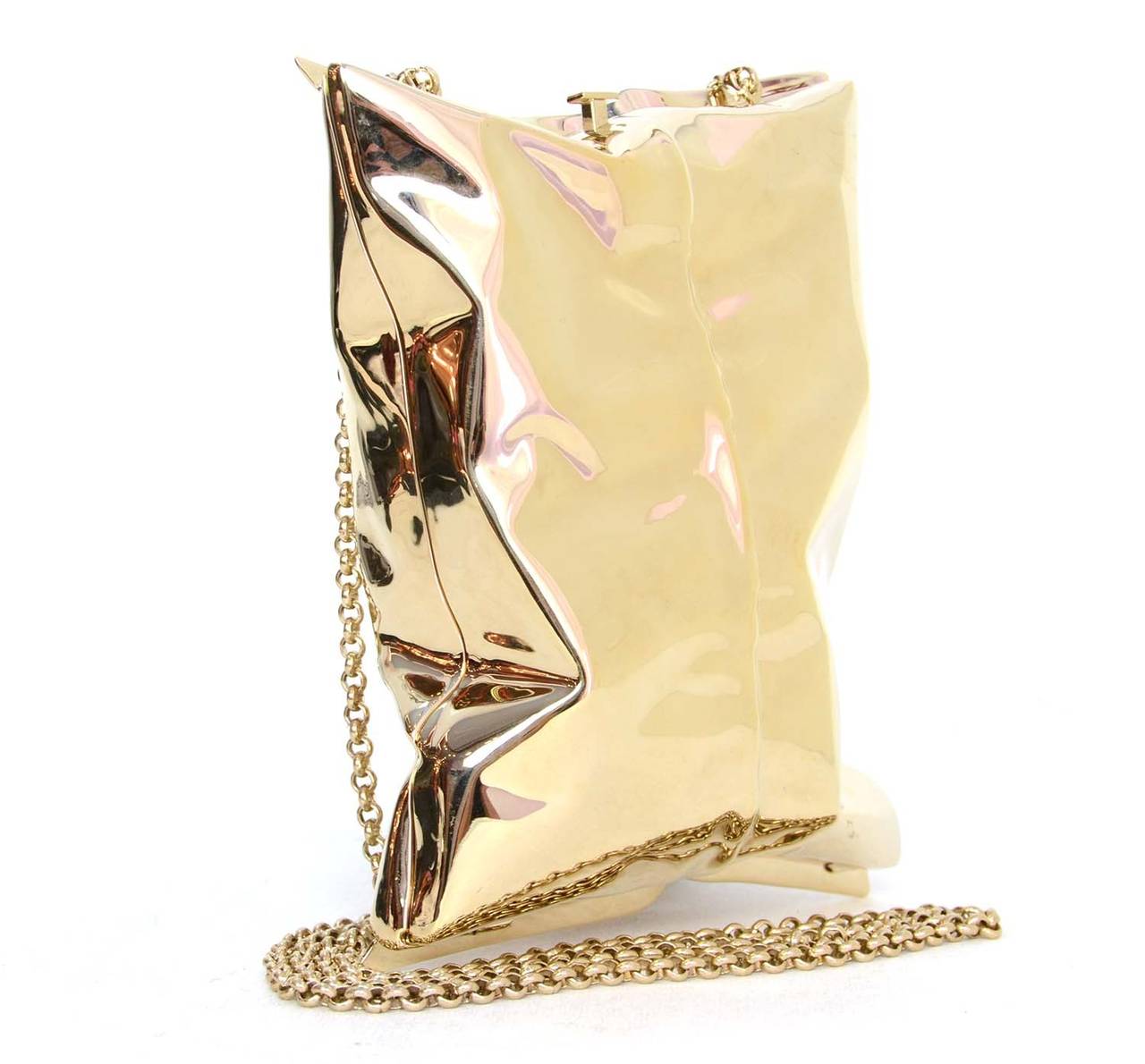 Anya Hindmarch Gold Crisp Packet Clutch Bag
Features detachable shoulder strap

    Made in: Italy
    Color: Pale gold
    Hardware: Pale gold
    Materials: Metal
    Lining: Beige suede
    Closure/opening: Button push hinge opening
   