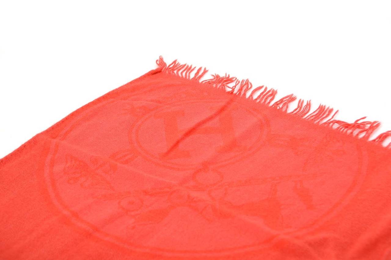 Hermes Coral Cashmere Shawl w/Fringe
Features H and equestrian print throughout

    Made in: France
    Color: Coral
    Composition: 85% cashmere, 15% silk
    Overall Condition: Excellent with no visible signs of