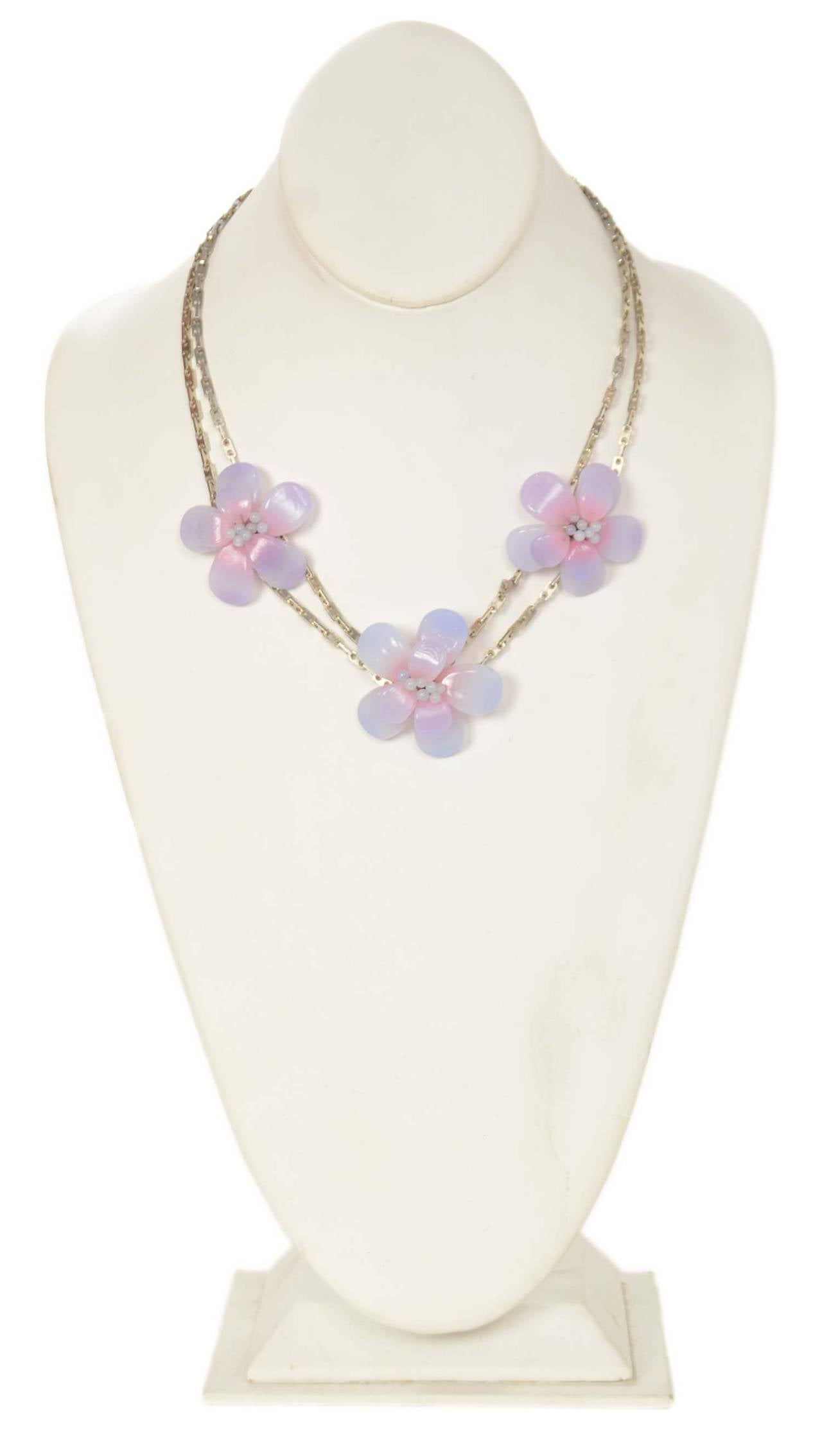Chanel Vintage '98 Lavender Resin Camelia Flower Necklace
Features double silvertone chain

    Made in: France
    Year of Production: 1998
    Stamp: 98 CC S
    Closure: Hook and eye closure
    Color: Silvertone and gradient lavender
   