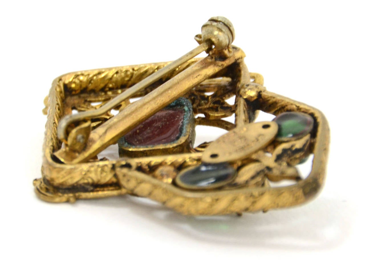 Chanel Vintage '83 Filigree Brooch 
Features red and green gripoix

Made in: France
Year of Production: 1983
Stamp: CHANEL CC 1983
Closure: Pin back closure
Color: Antiqued brass, red & green
Materials: Metal, glass, and crystal
Overall Condition: