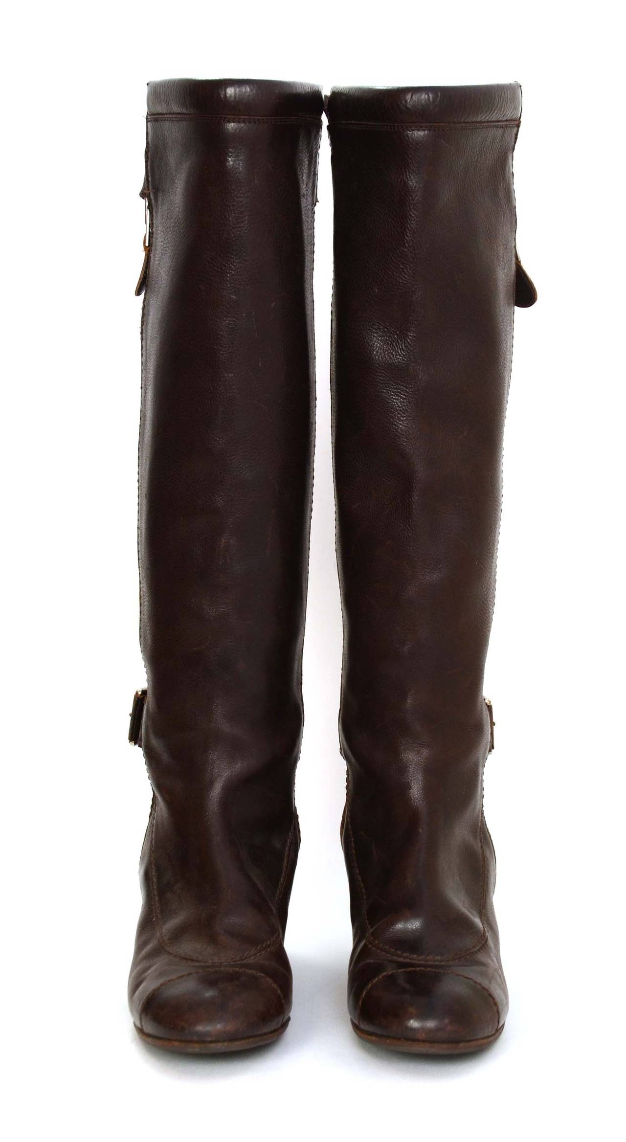 Chanel Brown Leather Riding Boots
Features double buckle, exposed side zipper and leather embossed CC on heel

    Made in: Italy
    Color: Brown
    Composition: Leather and metal
    Sole Stamp: Made in Italy 38
    Closure/opening: Side