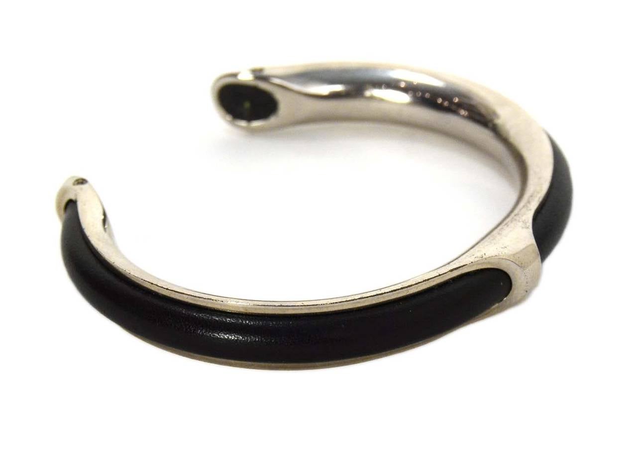 Hermes Black Leather & Silver Kyoto Cuff 
​Made in: France
Stamp: HERMES
Closure: None
Color: Black and silvertone
Materials: Leather and metal
Retail Price: $730 + tax
Overall Condition: Excellent with the exception of some faint scratching
