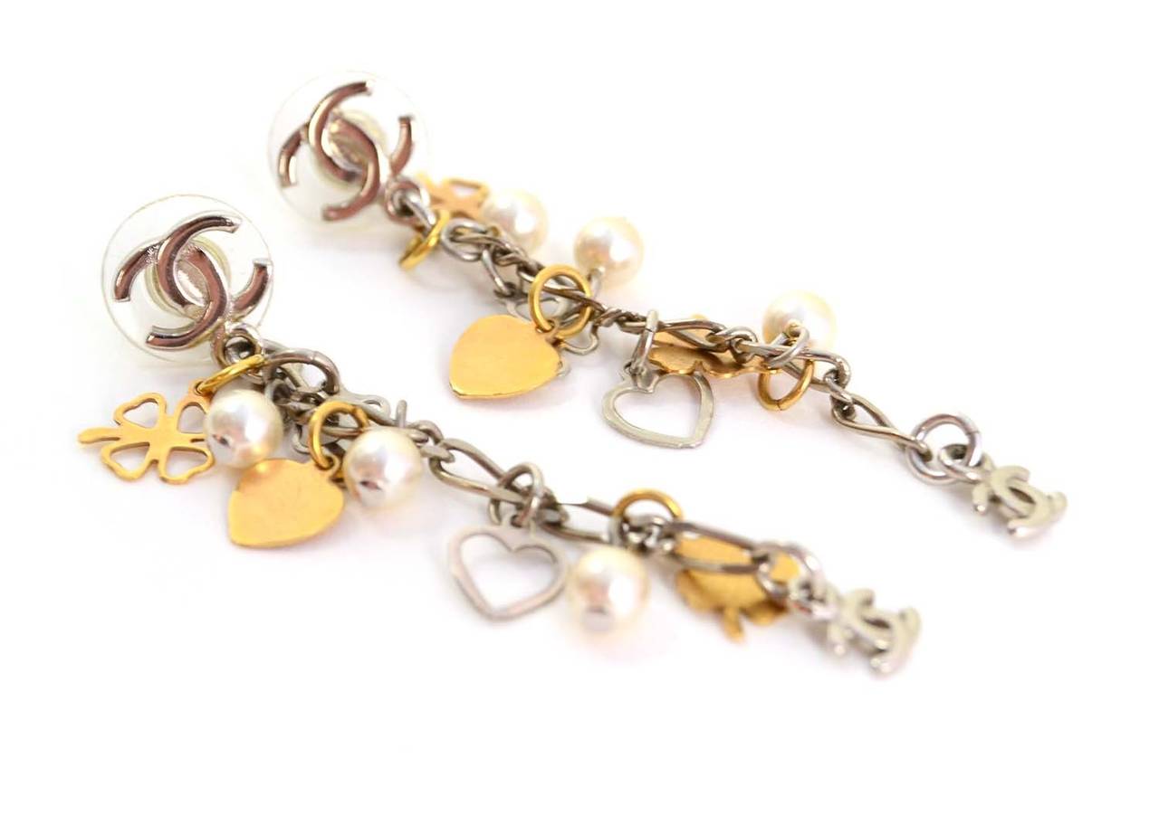 Chanel Gold/Silver & Pearl Charm Dangle Earrings
Features four leaf clover charms, heart charms, small pearls and CC charms 
Made in: France
Year of Production: 2006
Stamp: 06 CC A
Closure: Pierced ear back
Color: Goldtone, silvertone, and