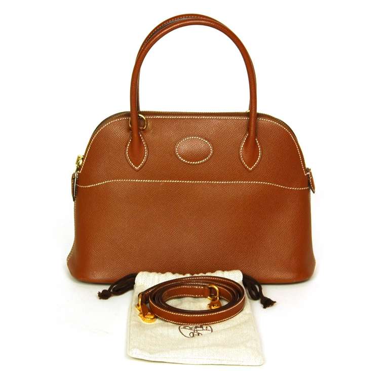 c.2008
Tan Epsom leather with beige contrast stitching.
Goldtone hardware.
Interior slip pocket
Can be carried by the rolled leather top handles or the detachable shoulder strap.
Five goldtone metal feet protect the base.
Zip top closure with