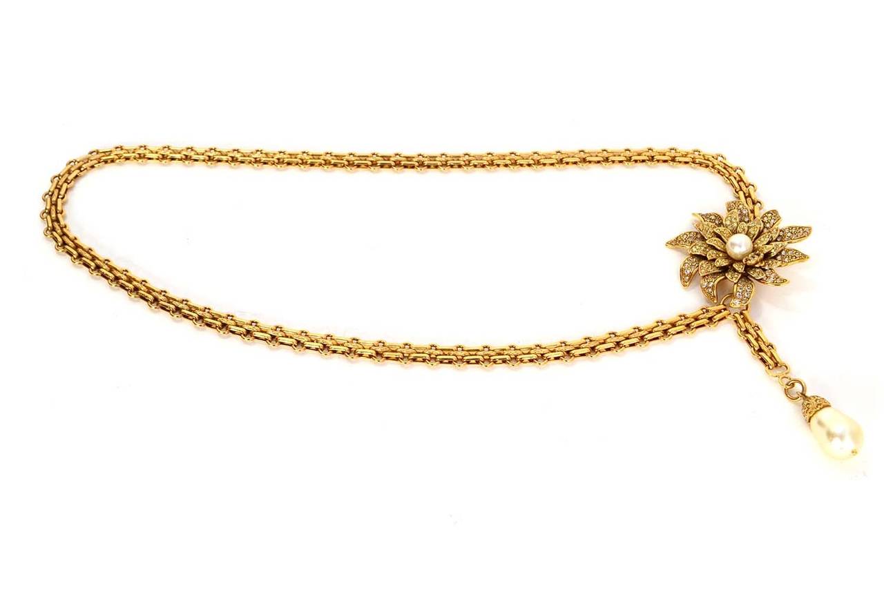 Chanel Bijoux Chain & Crystal Flower Belt 
Features tear drop style pearl with rhinestones at closure
Made in: France
Year of Production: 2005
Stamp: 05 CC A
Closure: Hook
Color: Goldtone and ivory
Materials: Metal, rhinestones and faux