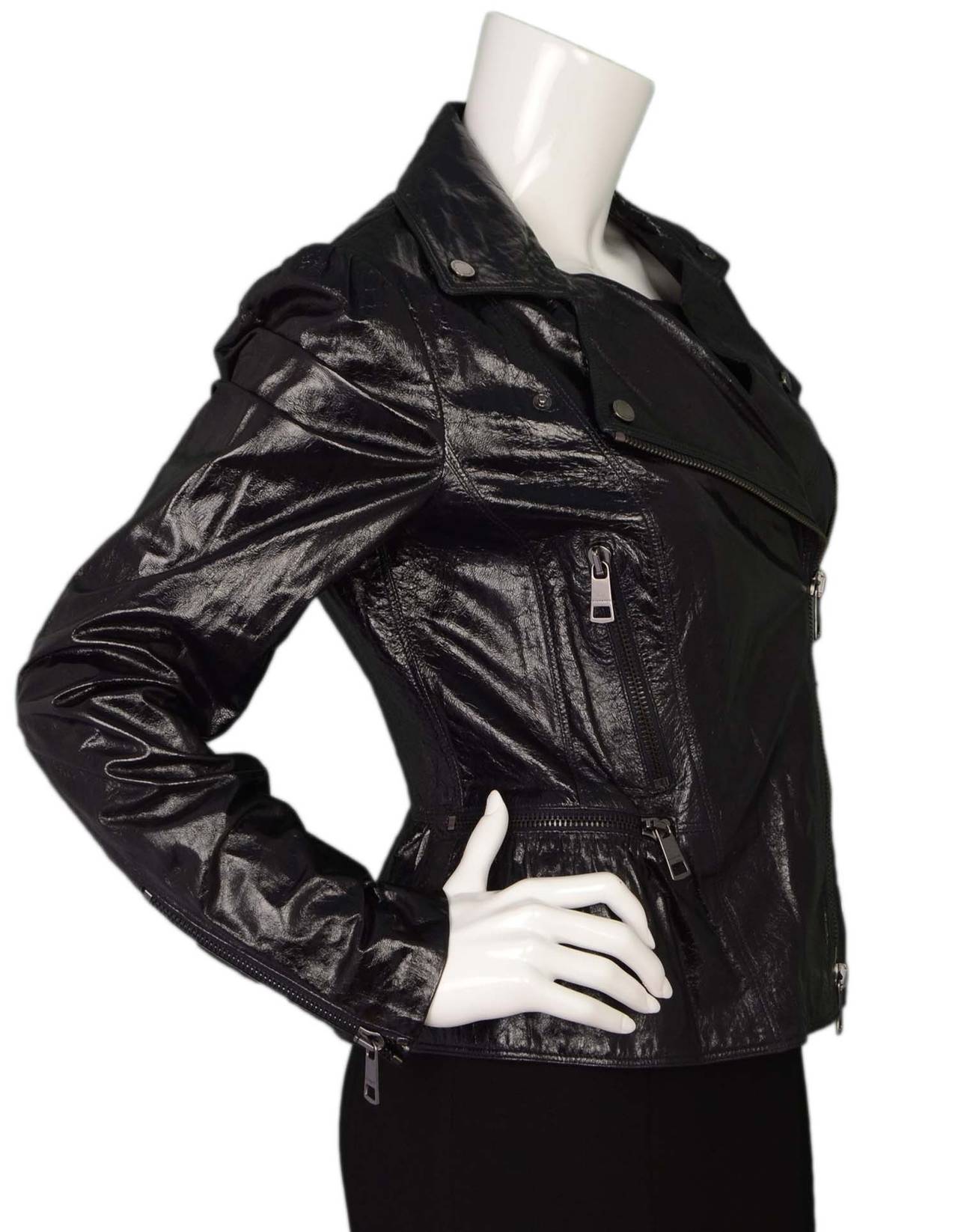 Burberry Black Patent Motorcyle Jacket
Features ruffle at hemline
Made in: Italy
Color: Black
Composition: 100% lambskin
Lining: Blue and black plaid, 40% cupro, 60% acetate
Closure/opening: Diagonal zip up front
Exterior Pockets: Three