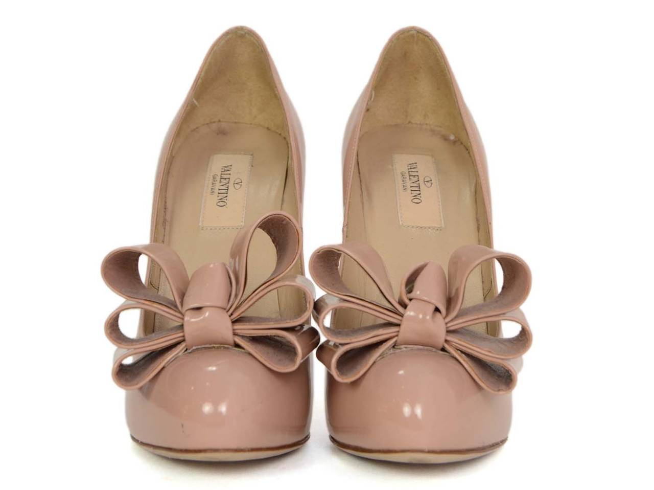 Valentino Nude Patent Leather Pumps
Features large bows at toes
Made in: Italy
Color: Nude
Composition: Patent leather
Sole Stamp: Valentino Garavani Made in Italy 37
Closure/opening: Slide on
Overall Condition: Very good with the exception