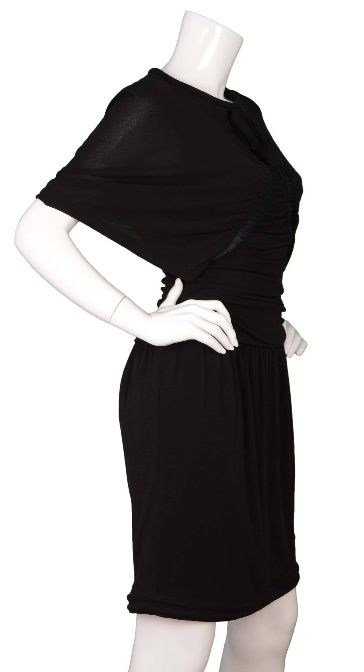 Chanel Black Silk Dolman Sleeve Dress
Features ruching throughout, tie at neckline, and rhinestone detailed heart button at back neckline
Made in: France
Year of Production: 2009
Color: Black
Composition: 100% silk
Lining: Black, 95% silk, 5%