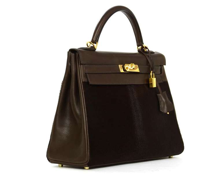 Luxurious chocolate brown calf hair paired with smooth Swift leather.
Gold tone hardware.
Comes with matching strap, clochette, lock & keys.
Lock and keys are number 120.
Four protective feet at base.
Can be carried by top handle or long