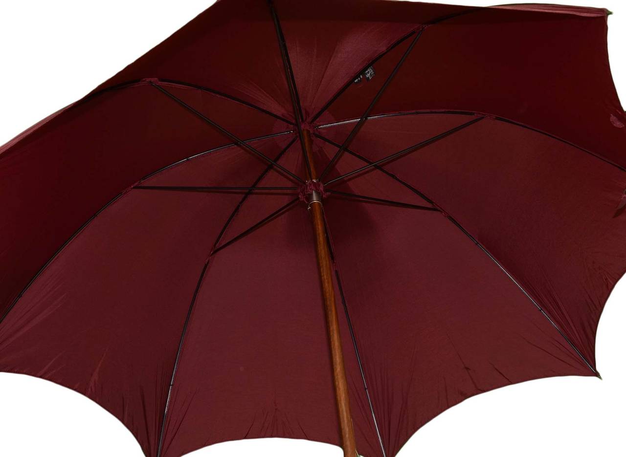 Hermes Burgundy Travel Umbrella
Features wooden handle and tip
Made in: England
Color: Burgundy and tan
Hardware: Wooden
Materials: Believed to be Nylon Taffeta textile, wood, and metal
Closure/opening: Push button & slide up to open and