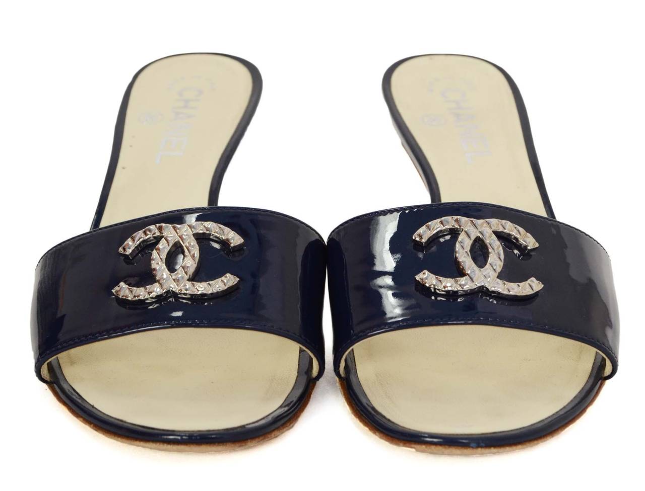 Chanel Navy Patent Mule Sandals
Features silvertone metal CC's at toes
Made in: Italy
Color: Navy, ivory and silvertone
Composition: Patent leather, leather and metal
Sole Stamp: CC Made in Italy 38
Closure/opening: Slide on
Overall