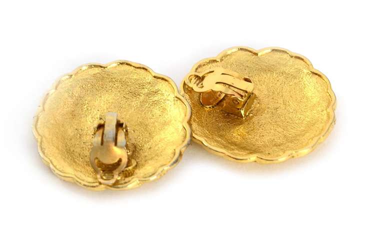 Chanel Vintage '87 Textured Gold Disc Clip On Earrings
Features three black CC's on each earring

Made In: France
Year of Production: 1987
Color: Goldtone and black
Materials: Metal
Closure: Clip on
Stamp: 2 CC 5
Overall Condition: Good preowned
