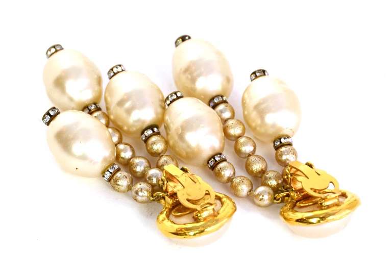 Chanel Vintage '93 Pearl Dangle Clip On Earrings
Features three hanging strands with rhinestone spacers

Made In: France
Year of Production: 1993
Color: Ivory and goldtone
Materials: faux pearls, rhinestones, and metal
Closure: Clip on
Stamp: 93 CC
