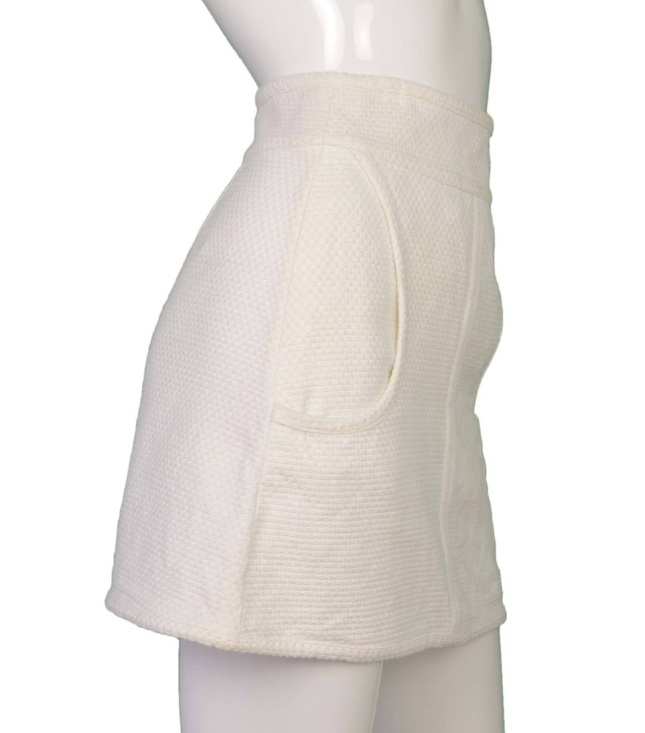 Chanel White Cotton Tennis Skirt 
Features large camelia flower with cc in center on left front panel of skirt
Made in: France
Year of Production: 2009
Color: White
Composition: 100% cotton
Lining: None
Closure/opening: Back center
