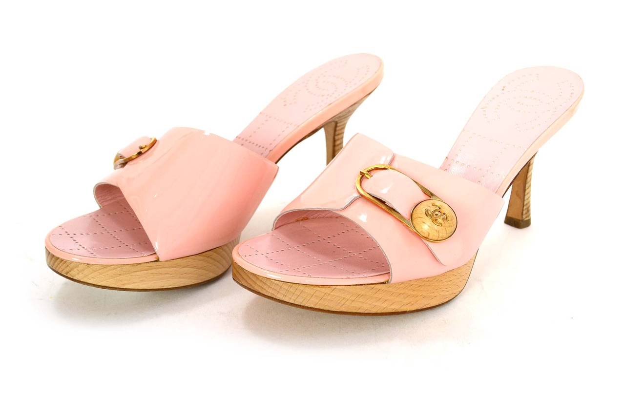 Chanel Pale Pink Patent Leather Open Toe Mules
Features stacked wooden heel
Made in: Italy
Color: Pink, goldtone, and tan
Composition: Patent leather, leather, wood and metal
Sole Stamp: CC 37 Made in Italy
Closure/opening: Slide on
Overall