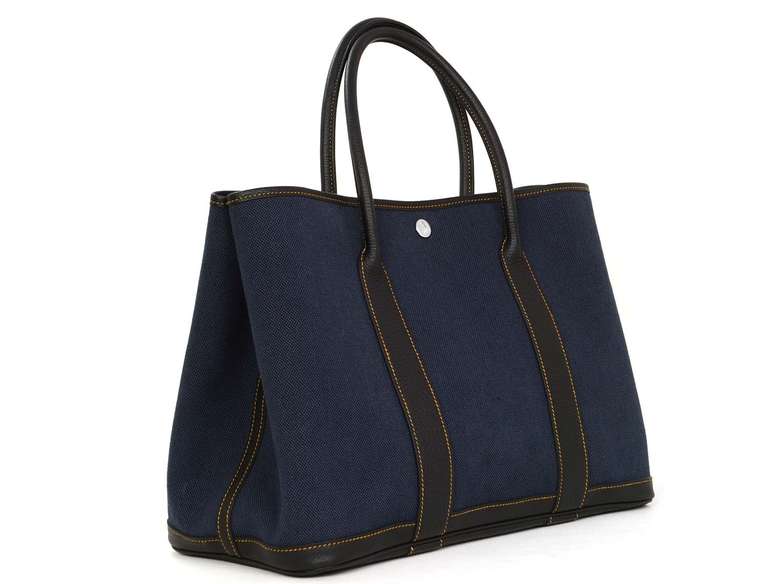 Retail $2,200
Navy blue toile canvas with navy leather trim.
Gold contrast stitching.
Palladium hardware.
Closes with snaps in the left and on either side.
Blind stamped P in a square.
Stamped HERMES PARIS MADE IN FRANCE.