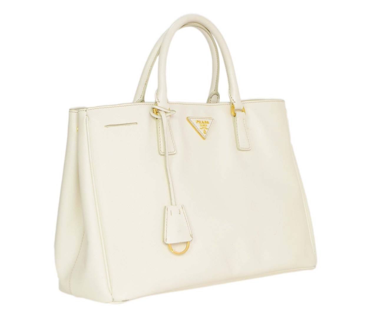 Prada White Saffiano Leather Tote Bag
Features white saffiano leather clochette with key ring on front of bag
Made in: Italy
Color: White and goldtone
Hardware: Goldtone
Materials: Leather and metal
Lining: Taupe Prada logo lined fine