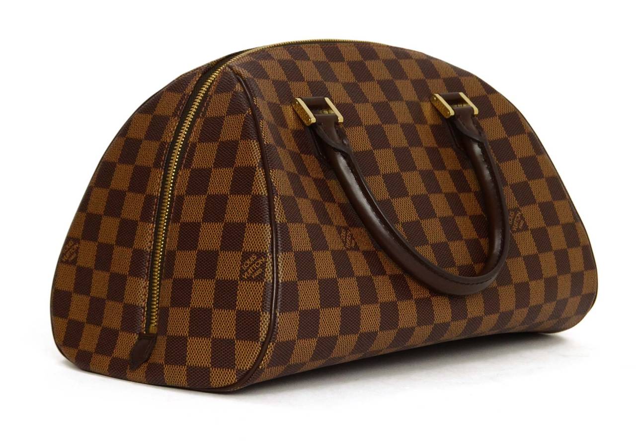 Louis Vuitton Damier Ribera Bag MM
 
Made in: Spain
Year of Production: 2005
Color: Brown and goldtone
Hardware: Goldtone
Materials: Canvas, leather, textile, and metal
Lining: Orange textile
Closure/opening: Zipper closure
Exterior Pockets: