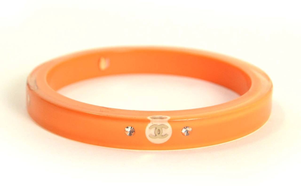 Chanel Orange Resin Bangle Bracelet
Features small CC's around bangle with two rhinestones on each side
Made in: France
Year of Production: 2008
Stamp: 08 CC C
Closure: None
Color: Orange
Materials: Resin, rhinestones and metal
Overall