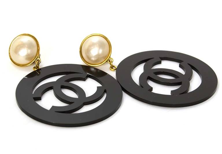 Made in France circa 1988
Stamped CHANEL 2 8 MADE IN FRANCE
Features large faux pearl clips with XL black resin circle CC
Goldtone metal surrounds pearl clip
Comes with Chanel Box

Total Length: 4.75
Faux pearl diameter: 1.1