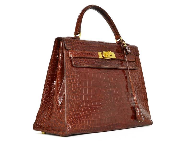 Hermes Cognac Crocodile Kelly Bag 32CM c. 1994

Age: c. 1994
Made in France
Materials: crocodile, goldtone metal
Classic Kelly has one interior zippered pocket and double slip pockets
Side straps slide into turn lock for closure
Blind date