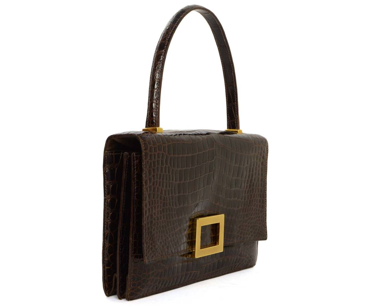 Hermes Vintage '62 Brown Glazed Croc Piano Bag
Made in: France
Year of Production: 1962
Color: Brown and goldtone
Hardware: Goldtone
Materials: Glazed crocodile and leather
Lining: Brown leather
Closure/opening: Flap top with goldtone square