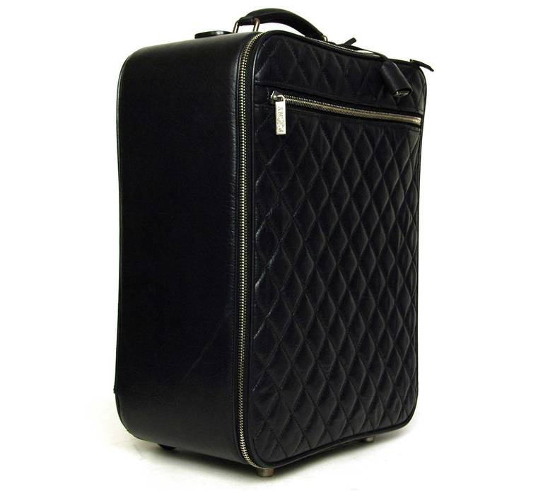 c.2007
Features rectangular distressed quilted leather rolling suitcase with collapsible handle. 
Exterior zippered pockets on front and back. 
Back has a slot for an card. 
Interior is lined in quilted teal fabric with 3 elastic slip pockets