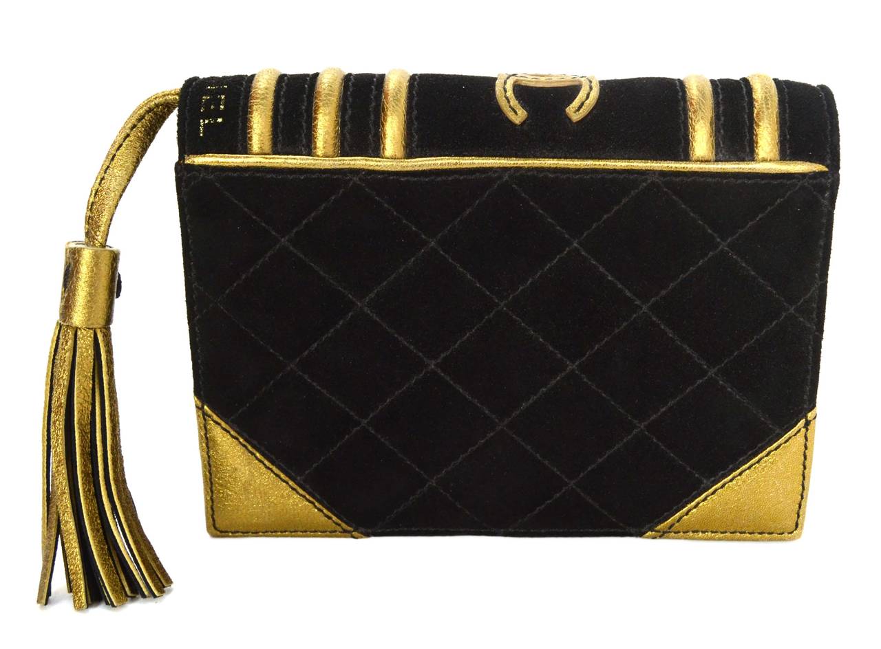 Chanel Rare Black Suede Book Clutch Bag
Features bronze trim and tassel
Made In: Italy
Year of Production: 2005
Color: Black and bronze
Hardware: None
Materials: Suede and leather
Lining: Black suede and beige Chanel logo printed