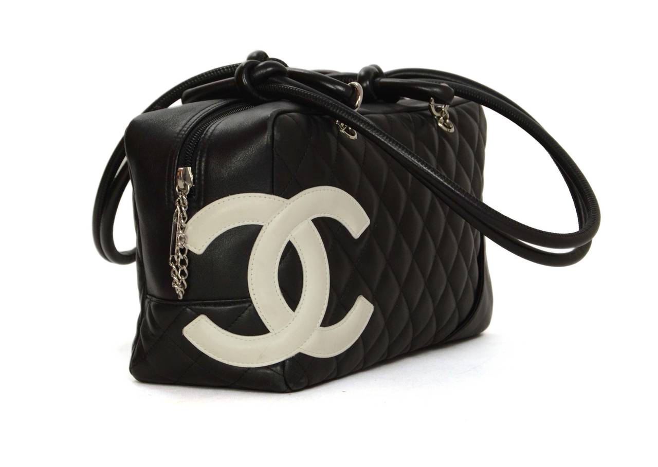 Chanel Black & White Leather Cambon Bag 
Features large white CC on corner
Made In: Italy
Year of Production: 2004-2005
Color: Black and white
Hardware: Silvertone
Materials: Leather and metal
Lining: Bright pink logo printed