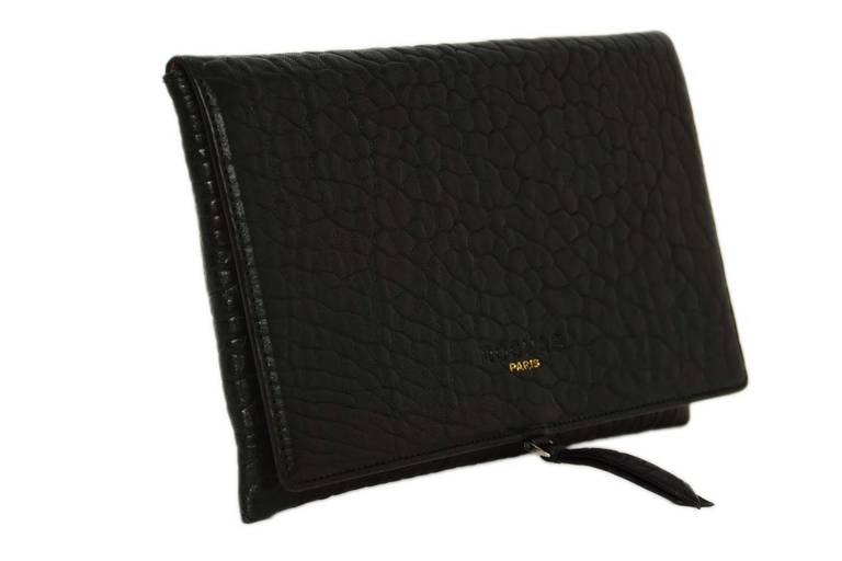 Features flap closure with front embossed ROCHAS and in stamped PARIS in gold
-Made in: Italy
-Year of Production: circa 2014
-Materials: Black textured leather
-Hardware: Silvertone
-Lining: Beige leather
-Exterior Pockets: None
-Interior
