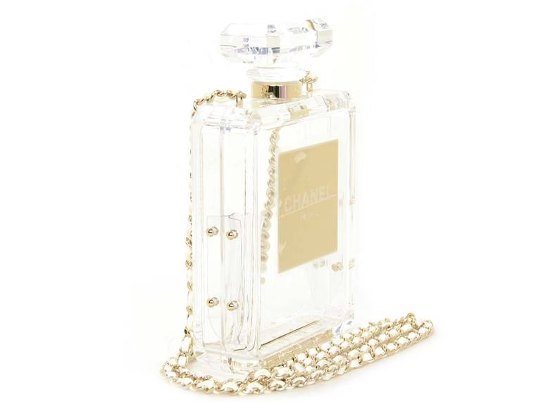 Chanel SOLD OUT 2014 Clear No 5 Perfume Bottle Bag
-Age: 2014
-Made in Italy
-Materials: clear plexiglass, white leather, goldtone chain links.
-Features clear plexiglass perfume bottle frame in the style of Chanel No. 5. Gold plate on front is
