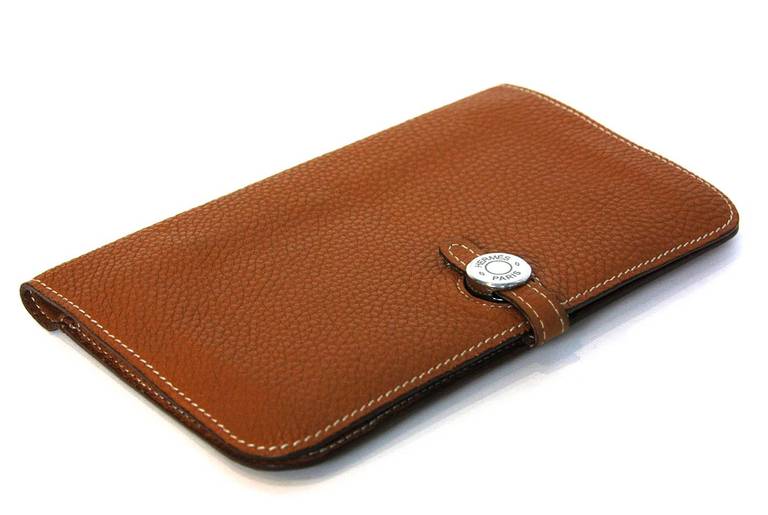 Hermes Tan Togo Leather DOGON Wallet

Age: c. 2006

Made in leather

Materials: leather, silvertone metal

Two compartments with five slip pockets

Coin purse insert with two small slip pockets

Closes with fold over flap that inserts
