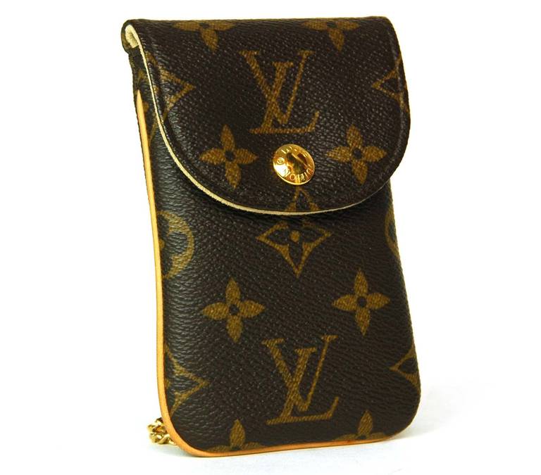 Louis Vuitton Monogram Cell Phone Case (Rt. $420)Age: c. 2009

Made in France

Materials: coated canvas, goldtone hardware, leather

Fits IPhone 4 or smaller

Hook and chain can be attached to a D ring

Snap button closure

Hidden stamp