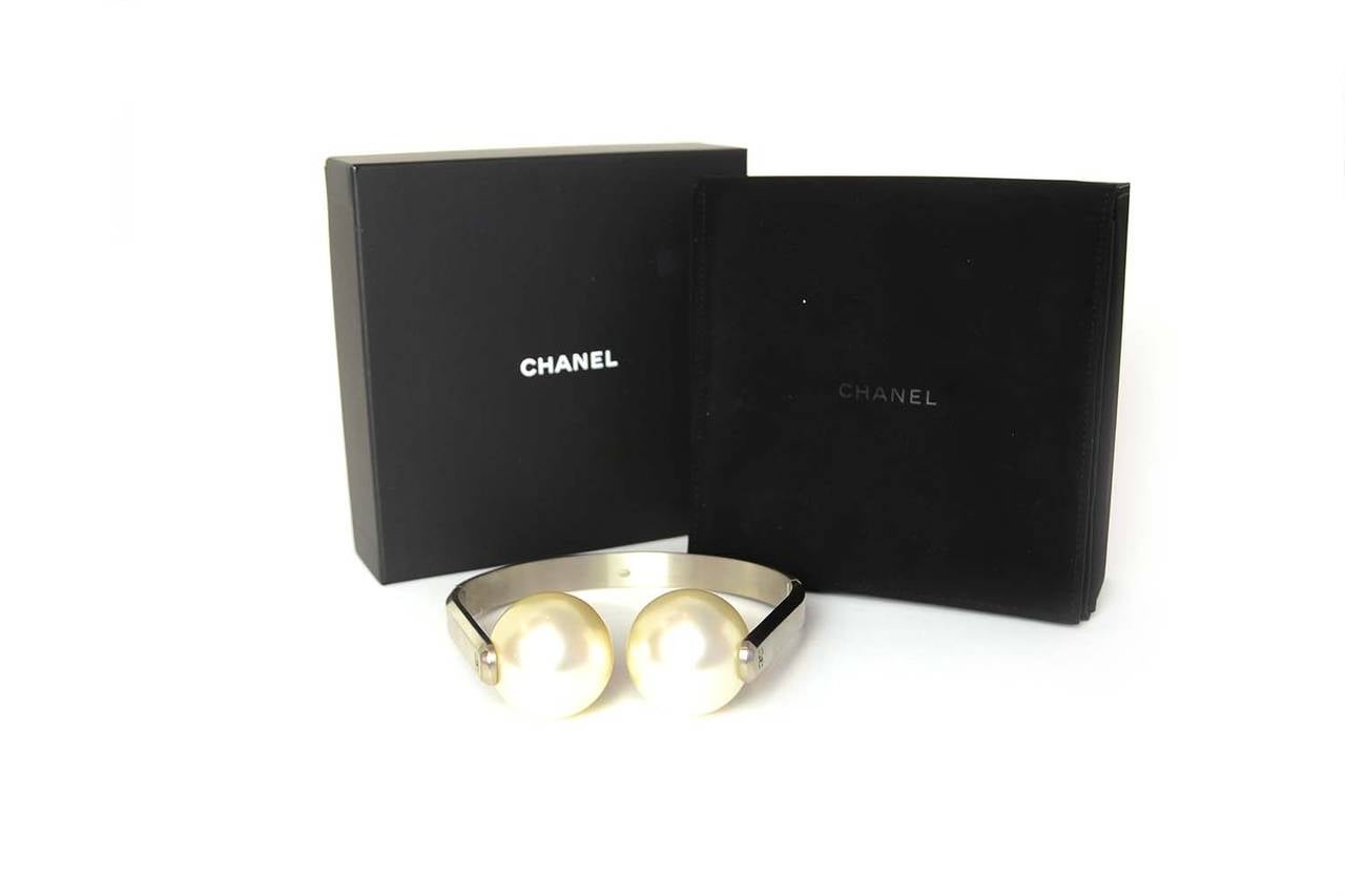 A Staple from the Spring/Summer 2014 Runway show

Year of Production: 2014 Spring/Summer
Color: Brushed silver, ivory
Materials: Faux pearl, metal
Stamps: CHANEL P14 CC S MADE IN FRANCE
Closure: Hindged
Includes: Chanel box, Chanel